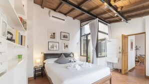 A neatly arranged bedroom with a bed, bedside tables, a bookshelf, and a window with curtains. - Monti Stairway to Heaven (Rome)
