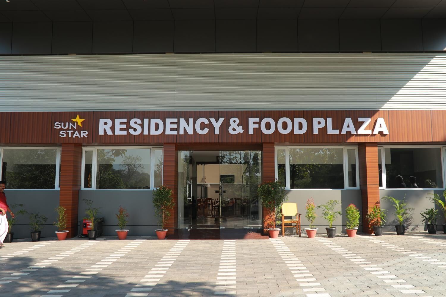 A building with a sign reading "RESIDENCY & FOOD PLAZA" and a logo for "SUN STAR".