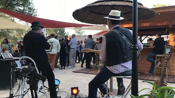 An outdoor event with a stage, musical instruments, and a crowd of people.