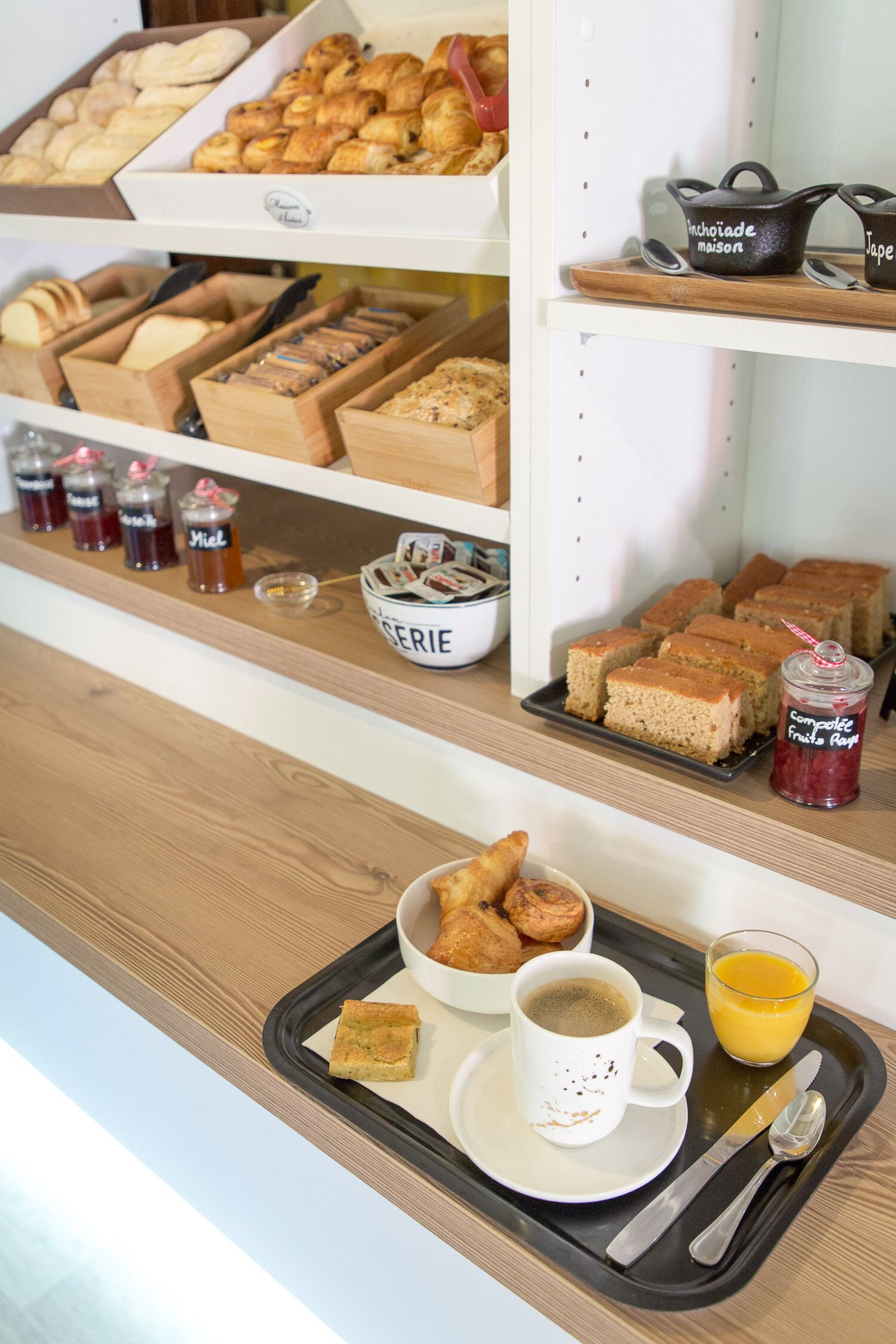 Una presentación de desayuno con bollería, pan y salsas.