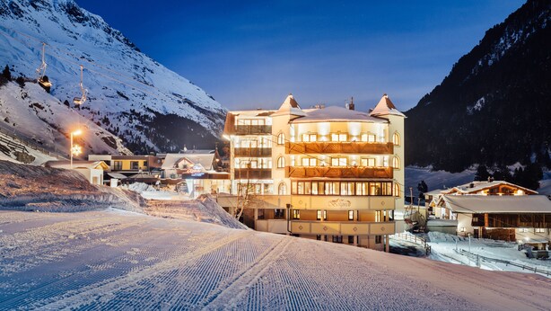 A multi-story hotel with a ski lift in the background, surrounded by snow-covered mountains. - Hotel Venter Bergwelt (Soelden)