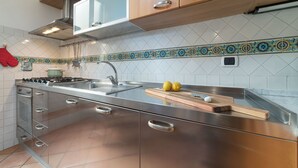 Una cocina moderna con electrodomésticos de acero inoxidable, armarios de madera y salpicadero decorativo de azulejos.