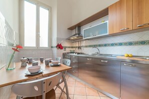 Una cocina moderna con electrodomésticos de acero inoxidable, encimera de madera y una ventana que proporciona luz natural.