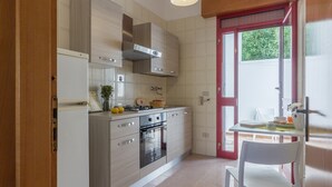 A compact kitchen with a stove, oven, and modern cabinetry. - Casa Gaia DX (Porto Cesareo)