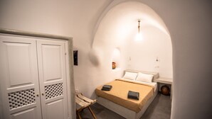 Ein Schlafzimmer mit einem Bett, einem Kleiderschrank und einem kleinen Tisch.
