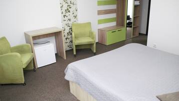 A bedroom with a bed, a desk, a chair, and a wardrobe.