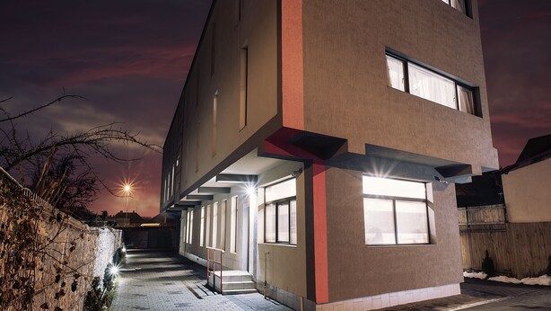 A multi-story building with a flat roof, large windows, and a staircase leading to the upper floors. - Vila William's (Brasov)