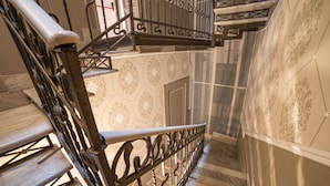 A staircase with ornate metal railings and patterned wall tiles. - Rooms Milano Duomo (Milan)