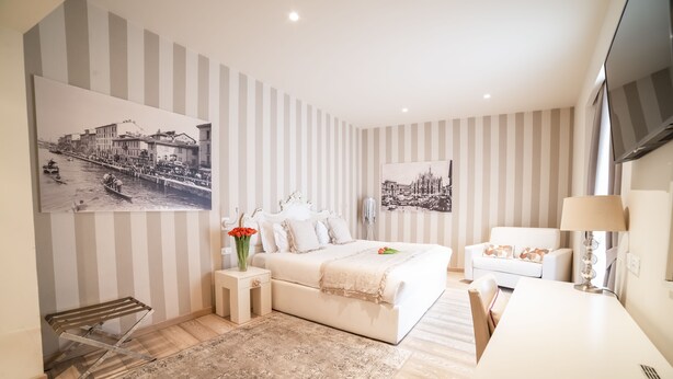 A modern bedroom with a bed, bedside tables, a TV, and artwork on the walls. - Rooms Milano Duomo (Milan)