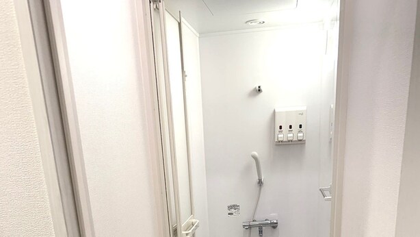 A small, narrow bathroom with a shower, a toilet, and a sink. - Hotel Owl Tokyo Shinbashi (Tokyo)
