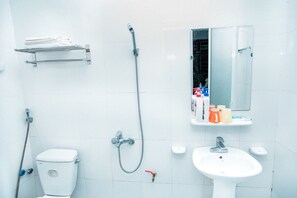 A bathroom with a toilet, a sink, a shower, and a towel rack.