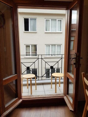 Blick vom Balkon mit zwei Holzstühlen und einem Metallgeländer.