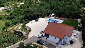 A modern house with a swimming pool, a garage, and a well-maintained garden.