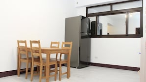 A small kitchen with a refrigerator, a dining table with four chairs, and a window with a view of the interior. - Home of 120 B&B (Jiaoxi)