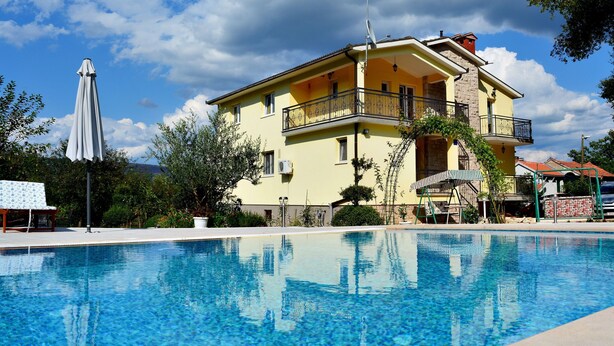Un edificio de dos pisos con piscina delantera.