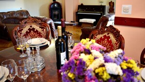 Una mesa de comedor dispuesta con copas de vino, una botella y un ramo de flores.