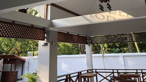 Un'ampia area interna con soffitto alto, diverse lampade a sospensione e grandi finestre che permettono l'ingresso della luce naturale.