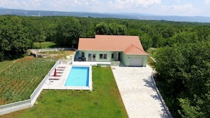 A house with a swimming pool, a garden, and a view of the surrounding landscape. - Holiday House 4M (Podbablje)