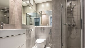 A modern bathroom with a toilet, a shower, and a vanity with a mirror. - Super-Apartamenty Love Deluxe (Poznan)