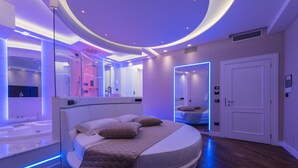 A modern bedroom with a circular bed, a built-in bathtub, and a large mirror. - LUX suites in Roma (Rome)