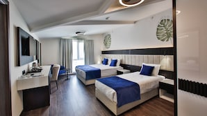 Habitación de hotel con dos camas, un escritorio y una silla.