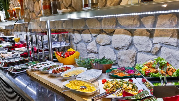 Un bufé con diferentes alimentos y utensilios.