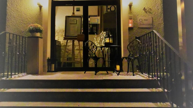 A hotel entrance with a glass door, a staircase, and a sign indicating the hotel name. - Hotel Restaurant Franziska (Straubing)