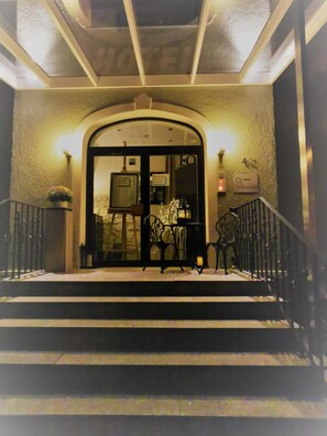 A hotel entrance with a glass door, a staircase, and a sign indicating the hotel name. - Hotel Restaurant Franziska (Straubing)
