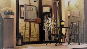 A hotel entrance with a reception desk, a potted plant, and a staircase leading to the interior. - Hotel Restaurant Franziska (Straubing)