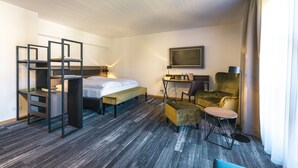 A hotel room with a bed, desk, chair, and a television on the wall. - Hotel Hohenwart Forum (Pforzheim)
