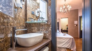 Deluxe kamer | Badkamer | Een douche, een regendouche, gratis toiletartikelen, een haardroger