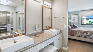 A modern bathroom with a large mirror, two sinks, and a vanity. - Penthouse Paradise with Amazing Views: 2BD, 2BA - (Isla Del Sol)