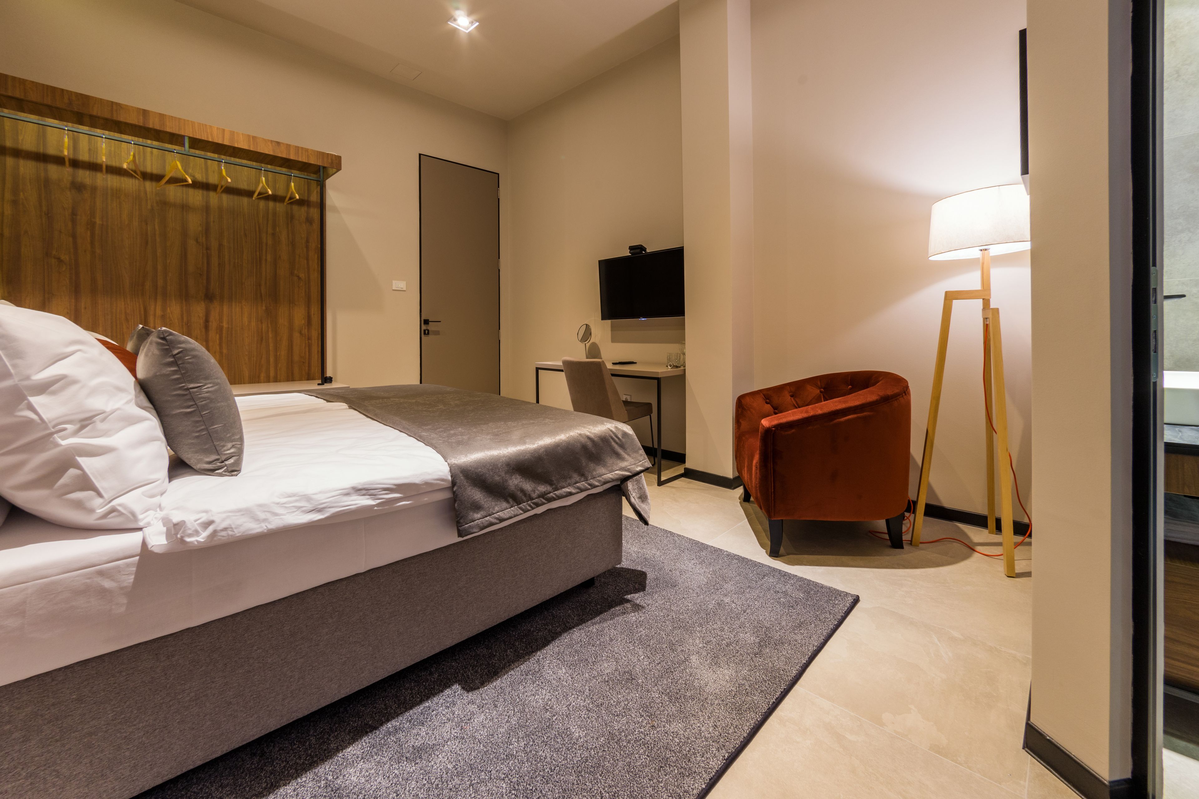 Habitació d'hotel moderna amb un llit gran, un escriptori, una cadira i una televisió.