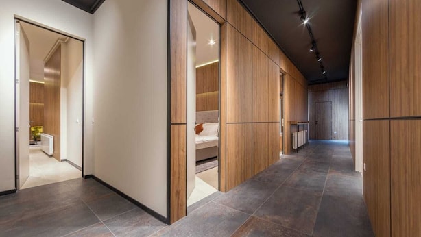 A hallway with wooden paneling, a bed, and a bathroom visible through an open door. - Dezman Luxury Center (Zagreb)