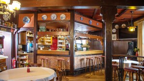 A restaurant interior with wooden beams, a bar area, and a dining section with stools and tables. - Lothringer Hof (Saarlouis)