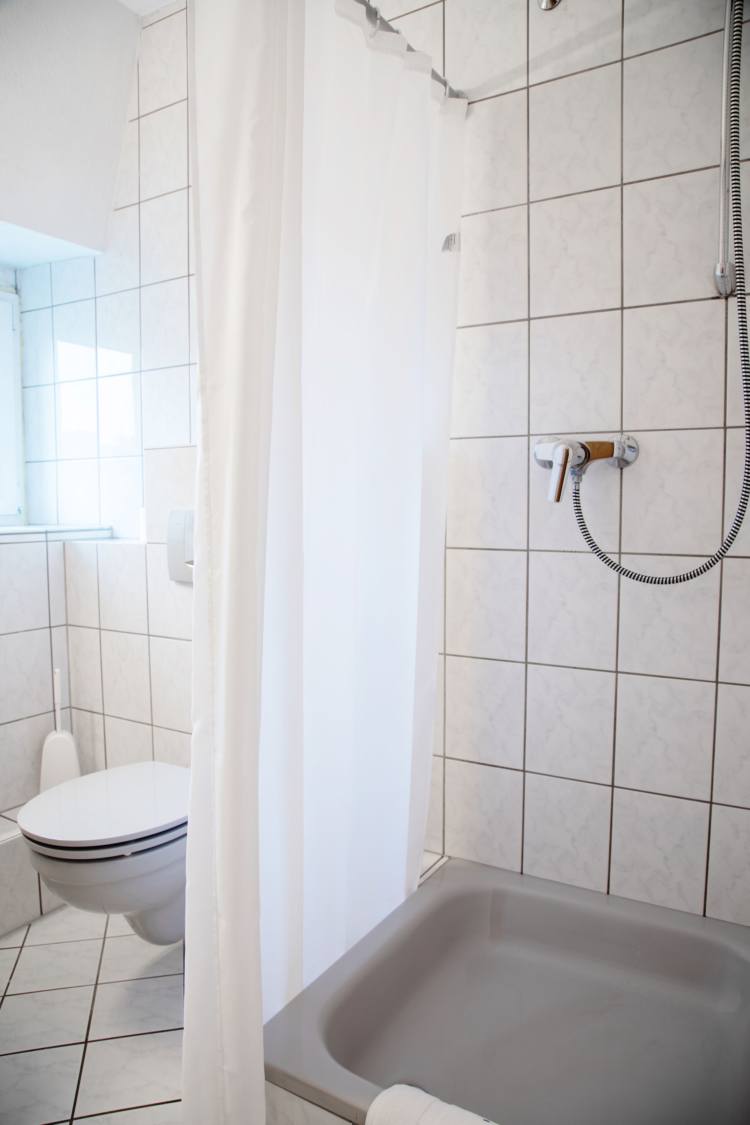 Ein Badezimmer mit Badewanne, Toilette und Dusche.