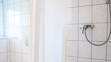 Ein Badezimmer mit Badewanne, Toilette und Dusche.