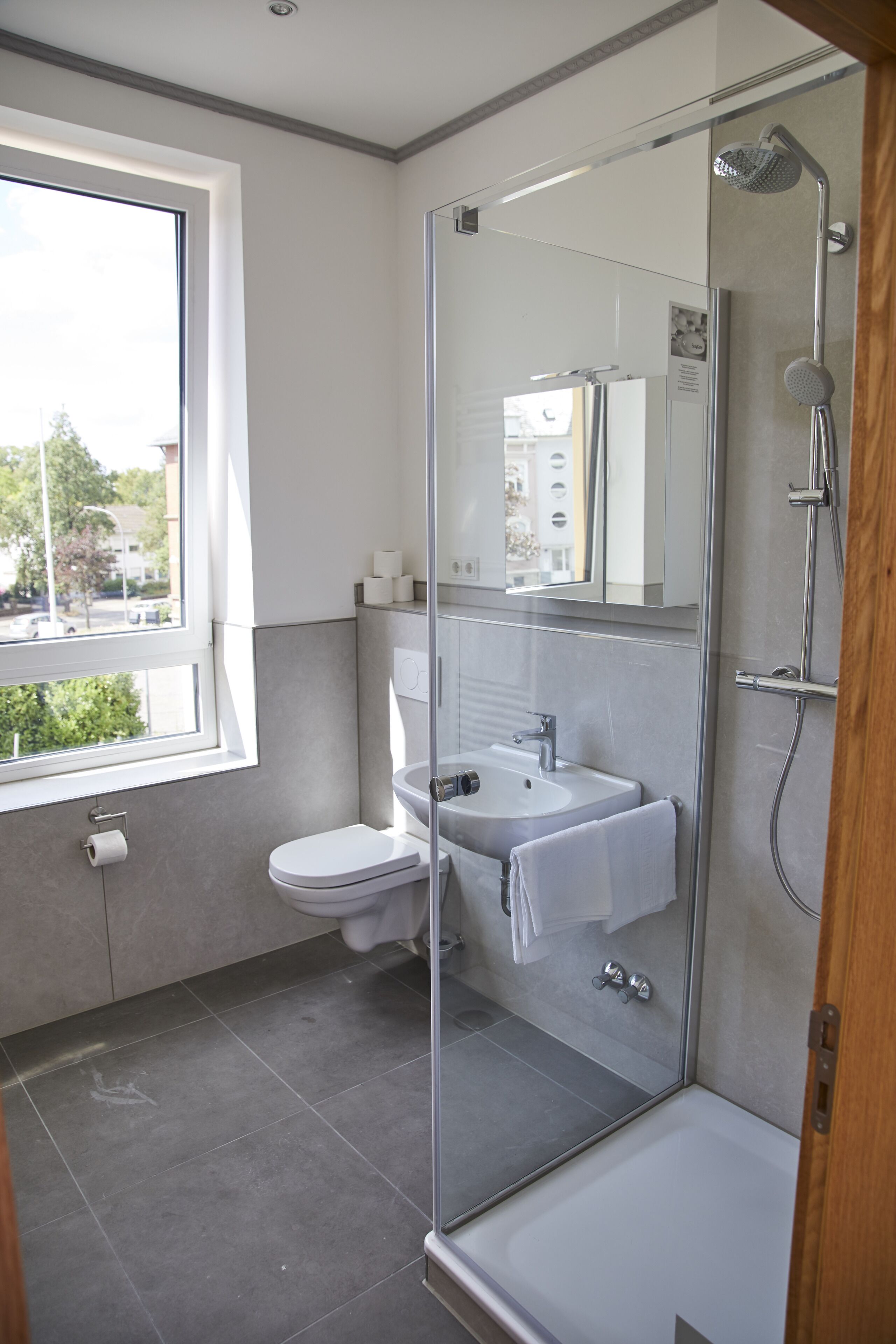 Un baño moderno con ducha envuelta en vidrio, inodoro y lavamanos.