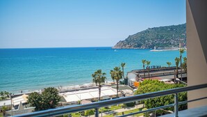 Vista costera con playa, palmeras y un edificio que dice "Yildiz Beach".
