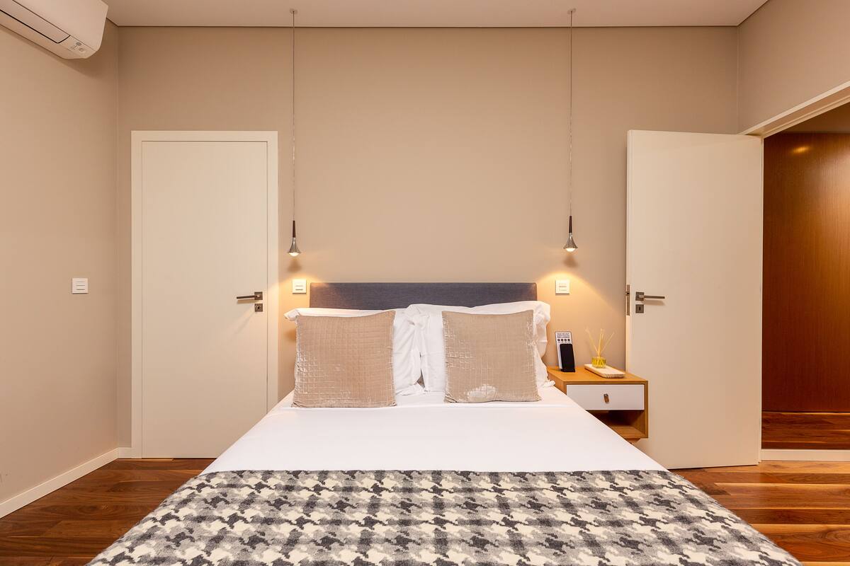 Une chambre à coucher avec un lit, deux lampes de chevet, une table de chevet et un plancher en bois.