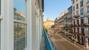 A city street with buildings on either side, a clear sky, and a distant historical building. - RS Porto Historic Center (Porto)
