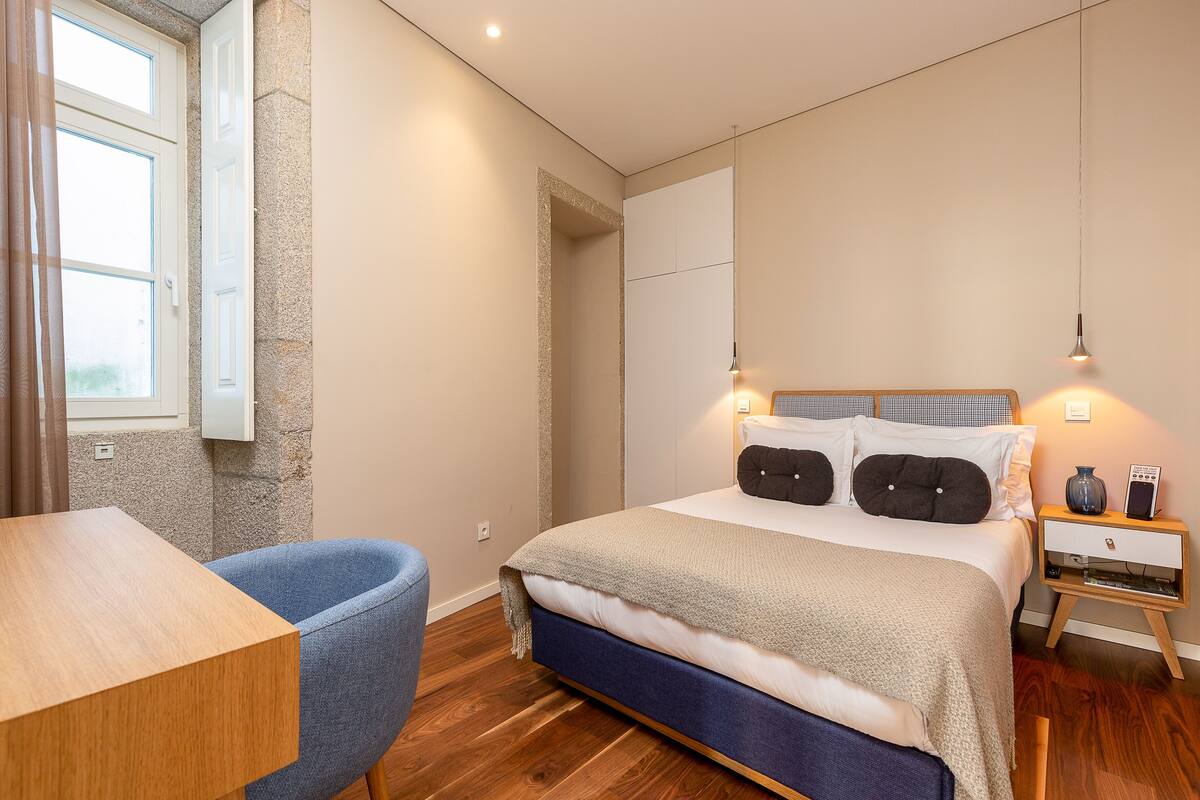 Une chambre à coucher avec un lit, une table de chevet, une lampe et une chaise.