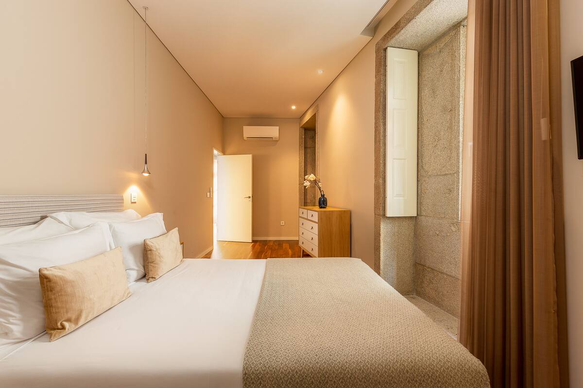Une chambre à coucher avec un lit, des lampes de chevet, une commode et un miroir.