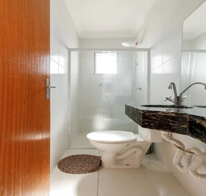 Un baño con inodoro, ducha y lavamanos.