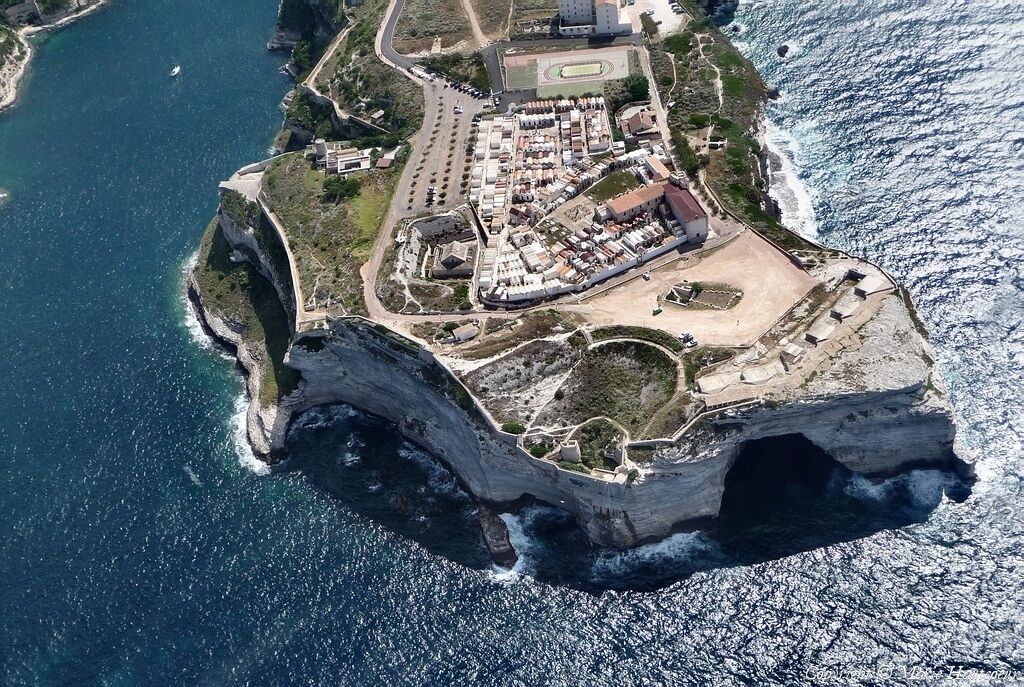Vista aèria d'una propietat costanera amb un gran penya-segat, una marina i un complex d'edificis.