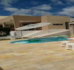 A swimming pool with a modern house in the background. - Casa Grande Gravata (Gravata)