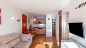 A modern apartment with a living room, kitchenette, and a TV. - Pleasant T2, parking - 4 guests (La Mongie)