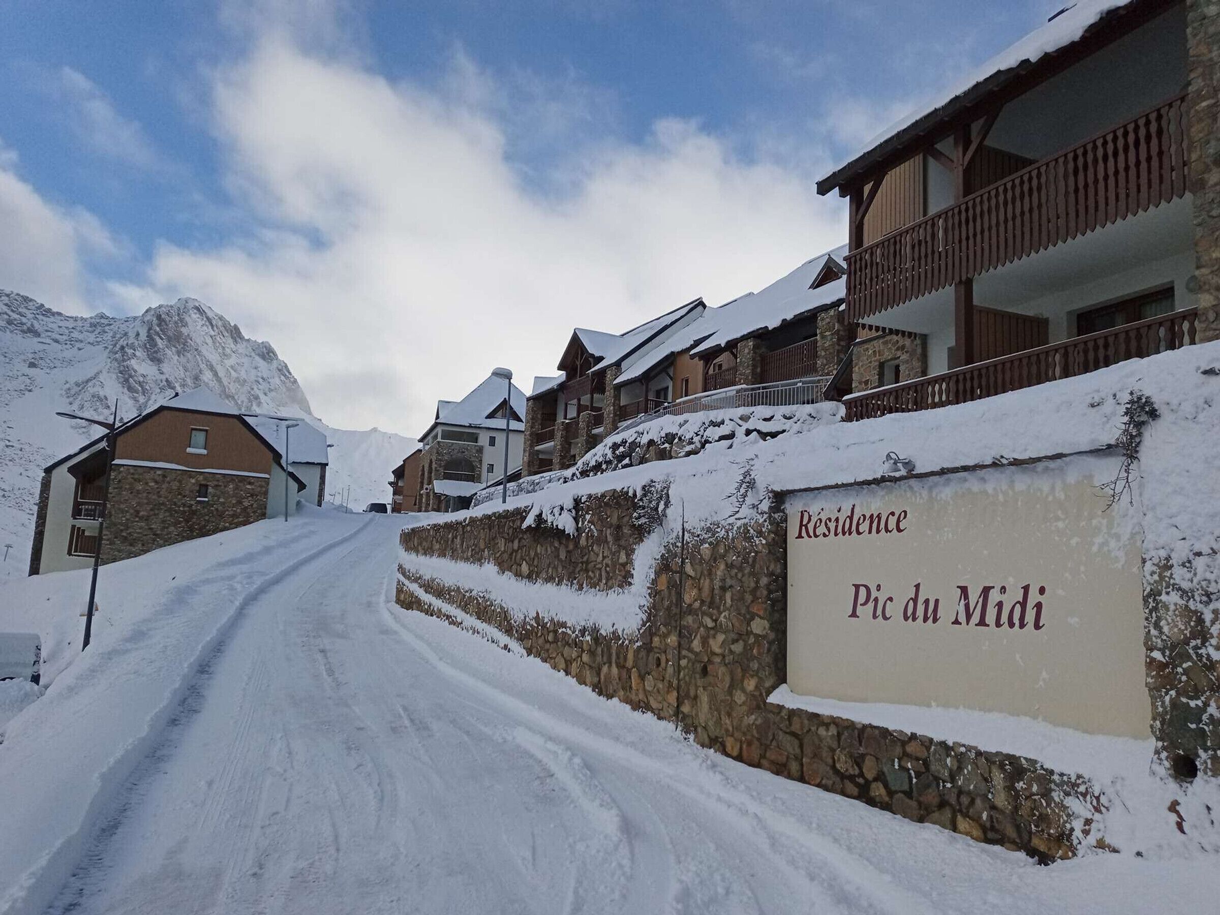 A snow-covered road leading to a building labeled "Residence Pic du Midi."