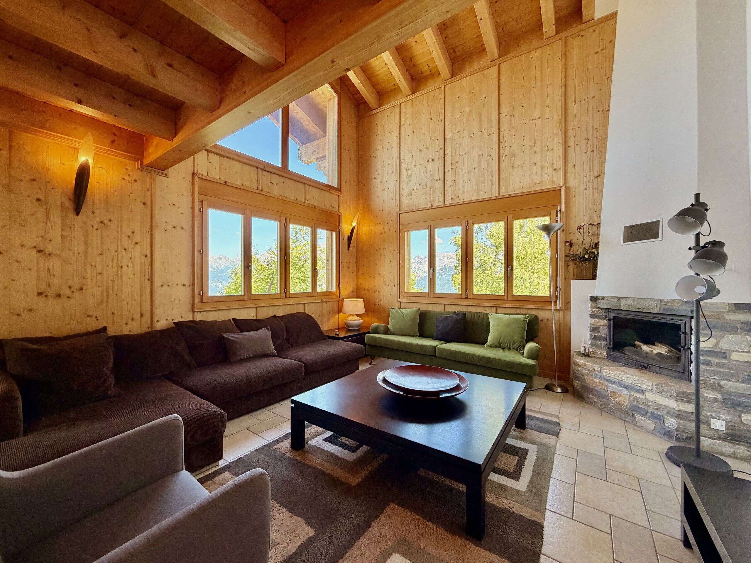 Ein Holzinterieur mit einer Couch, einem Couchtisch und einem Kamin.