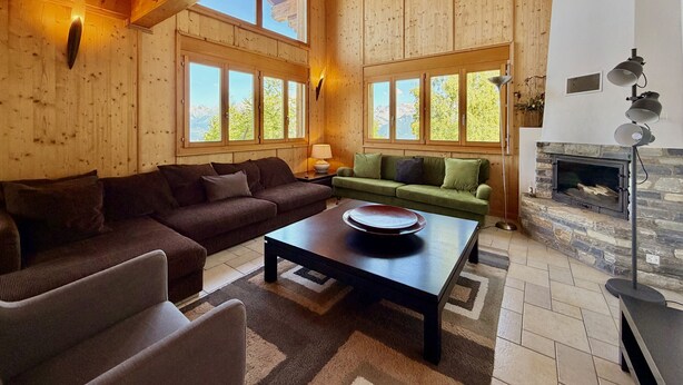 Un interior de madera con un sofá, una mesa de centro y una chimenea.